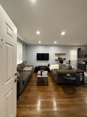 Chicago apartment for rent - A living room with a grey couch and a black television.