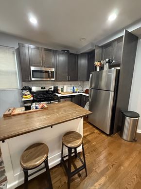 Chicago apartment for rent - A kitchen with a wooden counter and stools.