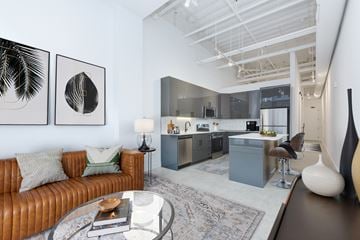 Chicago apartment for rent - A modern living room with a brown leather couch and a glass coffee table.