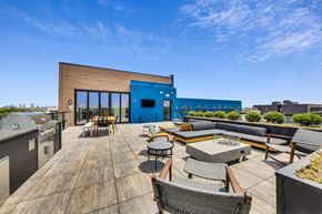 Chicago apartment for rent - a rooftop patio with a barbecue grill and a blue building in the background