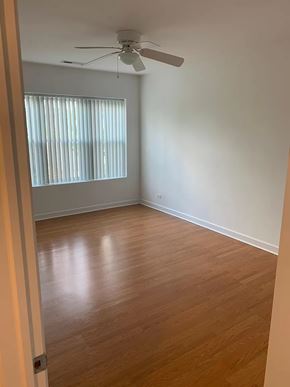 Chicago apartment for rent - an empty room with wooden floors and a ceiling fan