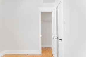 Chicago apartment for rent - A white door with a black handle is open to a hallway.