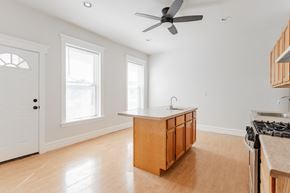Chicago apartment for rent - A kitchen with a wooden island and a fan.