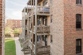 Chicago apartment for rent - the exterior of a brick apartment building with wooden stairs