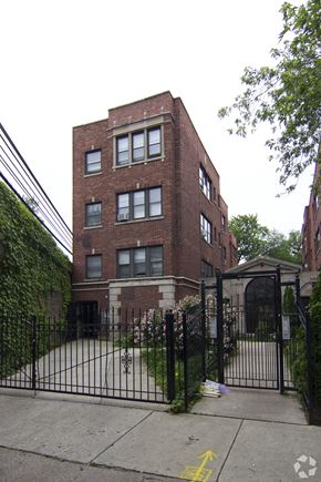 Chicago apartment for rent - a tall brick building with a gate in front of it