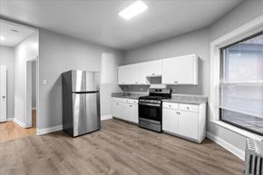 Chicago apartment for rent - A modern kitchen with stainless steel appliances and white cabinets.