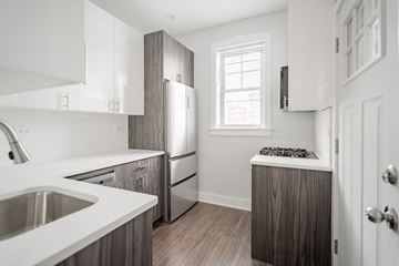 Chicago apartment for rent - a kitchen with white cabinets and a stainless steel refrigerator