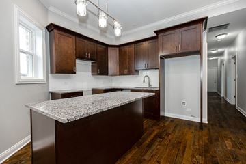 Chicago apartment for rent - A kitchen with dark wood cabinets and a granite countertop.