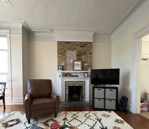 Chicago apartment for rent - A living room with a brown leather chair, a fireplace, and a television.