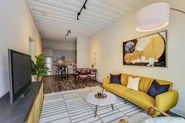 Chicago apartment for rent - a living room with a yellow couch and a tv