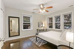 Chicago apartment for rent - a bedroom with a large bed and a ceiling fan