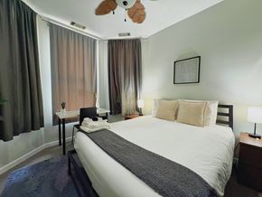 Chicago apartment for rent - A bedroom with a large bed and a ceiling fan.