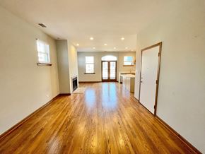 Chicago apartment for rent - an empty living room with a hard wood floor and a kitchen