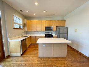 Chicago apartment for rent - an empty kitchen with wooden cabinets and a white counter top
