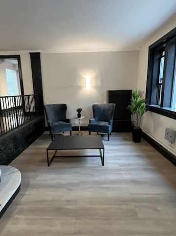 Chicago apartment for rent - A living room with a black coffee table and two blue chairs.
