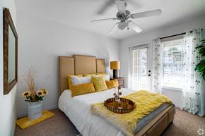 Clermont apartment for rent - A bedroom with a white bed and yellow pillows.