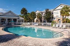 Clermont apartment for rent - A large swimming pool surrounded by a brick patio and lounge chairs.