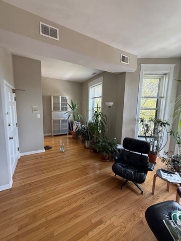Chicago apartment for rent - A living room with a black chair and wooden floors.
