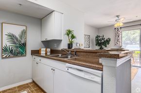 Mt. Dora apartment for rent - A kitchen with white cabinets and a brown countertop.
