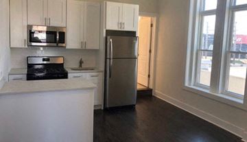 Chicago apartment for rent - A kitchen with white cabinets and a stainless steel refrigerator.