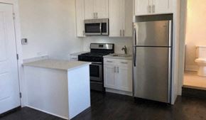 Chicago apartment for rent - A kitchen with a refrigerator, microwave, oven, and sink.