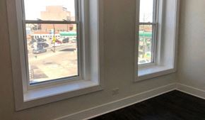 Chicago apartment for rent - A room with two windows overlooking a parking lot.