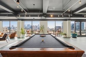 Chicago apartment for rent - A pool table in a room with a city view.