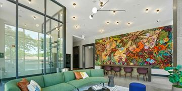 Chicago apartment for rent - A living room with a green couch and a large mural on the wall.