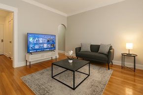 Chicago apartment for rent - A living room with a black couch, a television, and a coffee table.