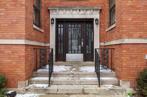 Chicago apartment for rent - the front door of a brick building with a black door