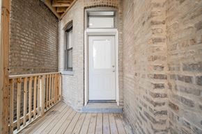 Chicago apartment for rent - the front porch of a brick house with a white door