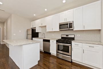 Chicago apartment for rent - A kitchen with white cabinets and stainless steel appliances.