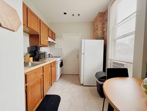 Chicago apartment for rent - A kitchen with wooden cabinets and a white refrigerator.