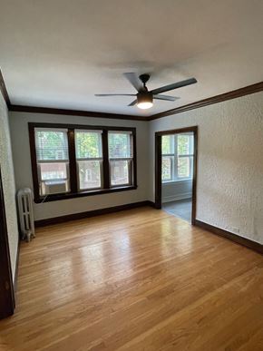Chicago apartment for rent - an empty living room with wood floors and a ceiling fan