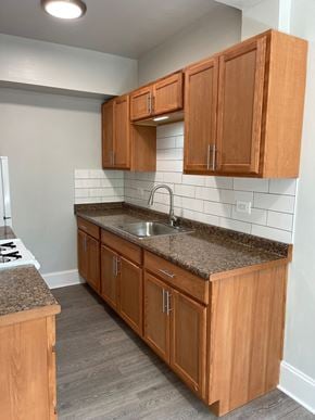 Chicago apartment for rent - an empty kitchen with wooden cabinets and granite counter top