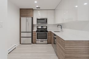 Chicago apartment for rent - A modern kitchen with a refrigerator, microwave, oven, and sink.