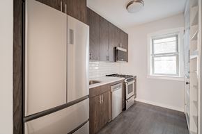 Chicago apartment for rent - a kitchen with white appliances and wooden cabinets and a refrigerator