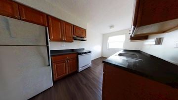 Skokie apartment for rent - A kitchen with wooden cabinets and a black countertop.