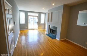 Chicago apartment for rent - an empty living room with a fireplace and wooden floors
