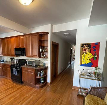Chicago apartment for rent - A kitchen with wooden cabinets and a painting on the wall.