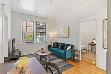 Chicago apartment for rent - A living room with a blue couch and a television.