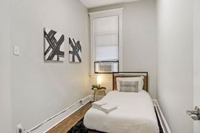 Chicago apartment for rent - a small bedroom with a bed and a window