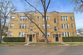 Chicago apartment for rent - a yellow brick building with a tree in front of it