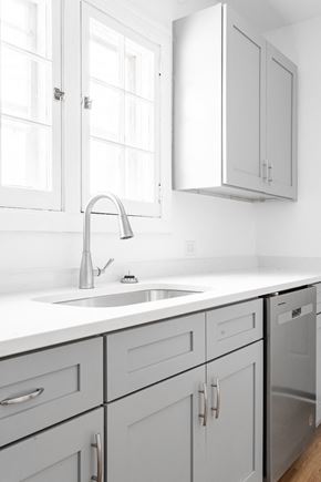 Chicago apartment for rent - A modern kitchen with a white countertop and grey cabinets.