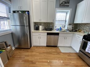 Chicago apartment for rent - a kitchen with white cabinets and a stainless steel refrigerator