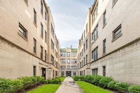 Chicago apartment for rent - A long, narrow courtyard between two buildings with greenery on the sides.