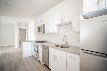 Chicago apartment for rent - A kitchen with white cabinets and appliances.