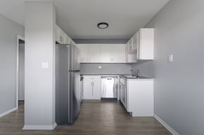 Grayslake apartment for rent - A modern kitchen with white cabinets and a grey refrigerator.