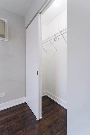 Chicago apartment for rent - a bedroom with white walls and a closet with a mirrored door