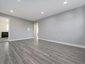 Chicago apartment for rent - A spacious room with grey flooring and white walls.